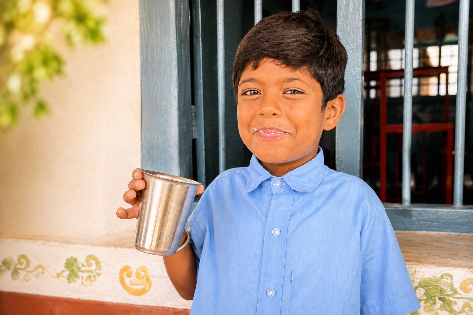 Boy with milk mustache holding cup
