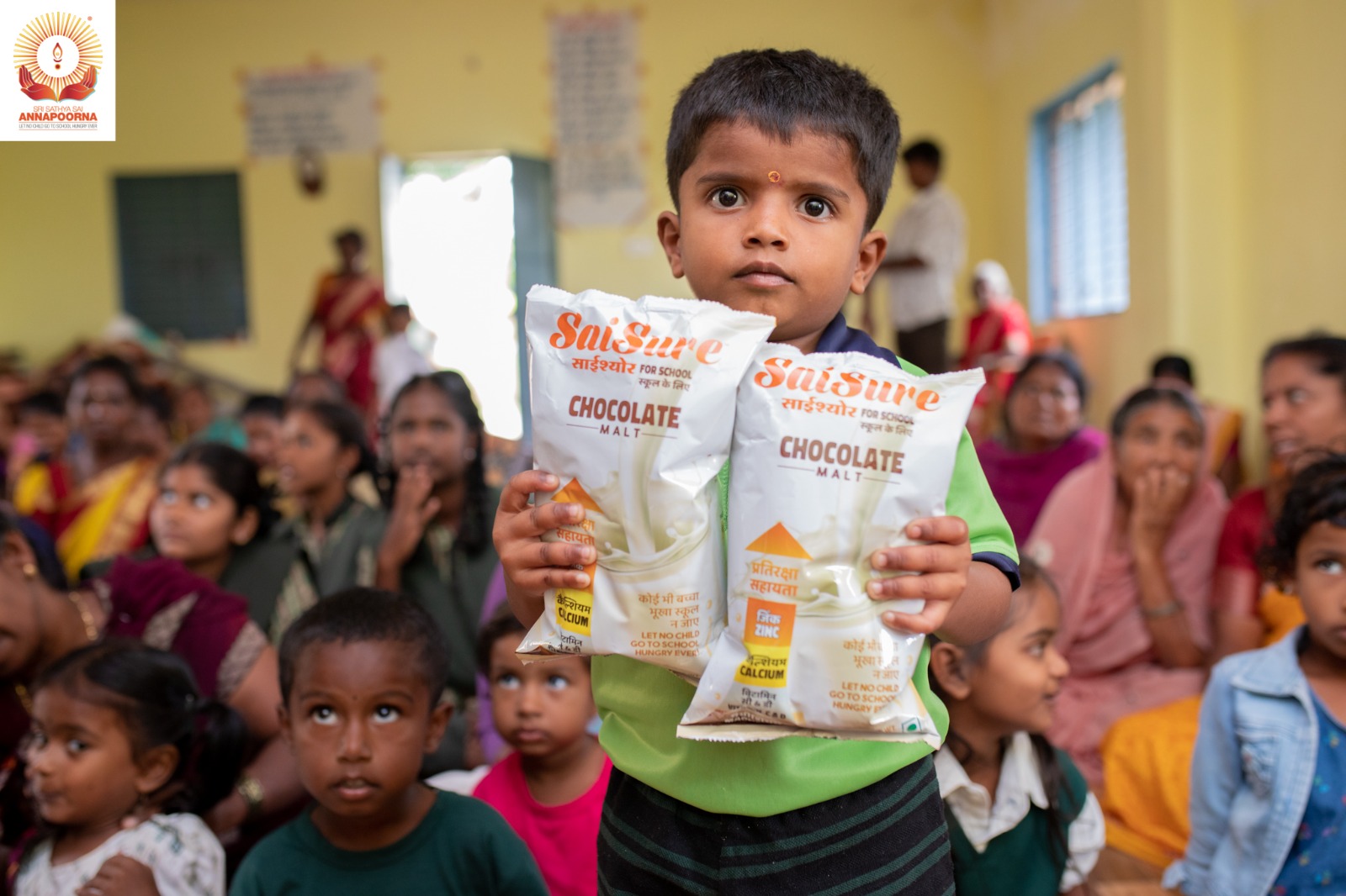 Child holding SaiSure nutrition packets